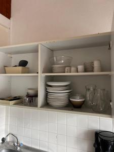 a kitchen shelf with plates and bowls and dishes at Le village de Sèchemailles in Ambrugeat