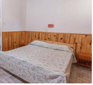 um quarto com uma cama e uma parede de madeira em Le village de Sèchemailles em Ambrugeat