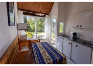 uma cozinha com uma mesa, um lavatório e uma janela em Le village de Sèchemailles em Ambrugeat