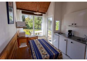 a kitchen with a table and a sink and a window at Le village de Sèchemailles in Ambrugeat