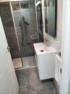 een badkamer met een douche, een wastafel en een spiegel bij Appartamento Francy in Chayofa