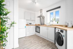 uma cozinha branca com máquina de lavar e secar roupa em 2 Bedroom Deluxe Apt - Off-Street Parking - Wifi - Netflix - 57C em Sleightholme