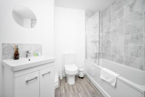 baño blanco con lavabo, bañera y aseo en 2 Bedroom Deluxe Apt - Off-Street Parking - Wifi - Netflix - 57C en Sleightholme