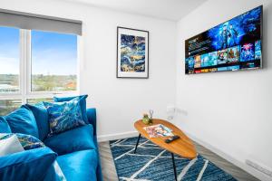 ein Wohnzimmer mit einem blauen Sofa und einem Tisch in der Unterkunft 2 Bedroom Deluxe Apt - Off-Street Parking - Wifi - Netflix - 57C in Sleightholme