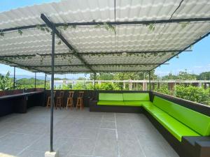 eine Pergola auf dem Dach eines Gebäudes mit grüner Couch in der Unterkunft Villa privada en condominio San Simon in Carmen de Apicalá