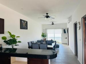 a living room with a ceiling fan and a table at Holiday apartment at La Diosa condos Isla Mujeres in Isla Mujeres