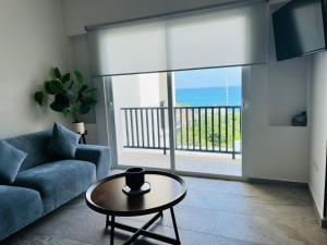 a living room with a couch and a table and a balcony at Holiday apartment at La Diosa condos Isla Mujeres in Isla Mujeres
