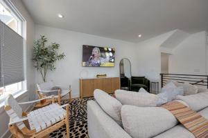 ein Wohnzimmer mit einem Sofa und einem TV in der Unterkunft En-Vogue Vacay - Rooftop Deck - 4 mins to TSU in Nashville
