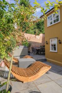 a patio with a wooden bench and a table at Huge & Deluxe 600 Year Old Essex Manor House in Saffron Walden