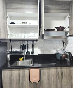 a kitchen with a sink and a counter top at Coast Residences - 2 Bedroom with Balcony facing Mall of Asia, Manila Bay & Pool View in Manila