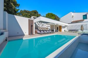 a swimming pool in front of a house at Villa Incanto in Pješčana Uvala 