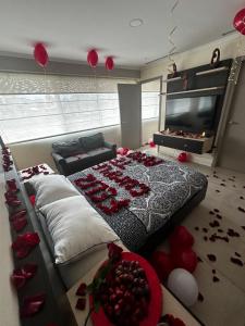 a bedroom with a large bed with red roses on the floor at Depa de lujo con piscina y jacuzzi in Guayaquil