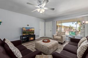 a living room with a couch and a tv at Coastal Cabana - Walk to Old Town - 2 Pools in Scottsdale