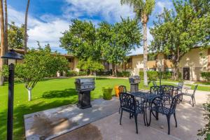 a patio with chairs and tables and a grill at Coastal Cabana - Walk to Old Town - 2 Pools in Scottsdale