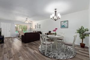 a dining room and living room with a table and chairs at Coastal Cabana - Walk to Old Town - 2 Pools in Scottsdale