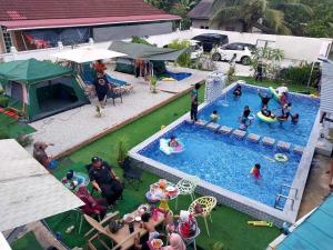 uma vista superior de uma piscina com pessoas a brincar nela em Casa LiLa Tiny Stay & Pool Kota Bharu,free wifi,free parking 