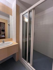 a bathroom with a sink and a shower at Hotel Alef in Krakow