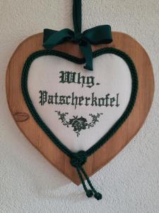 a wooden heart sign with a bow on a wall at Nockhof in Innsbruck