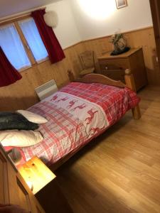a bedroom with a bed with a red blanket at Charmant T2 proches centre village in Les Rousses
