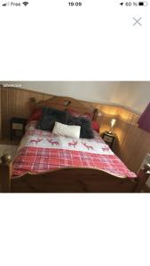 a bedroom with a bed with a red and white blanket at Charmant T2 proches centre village in Les Rousses