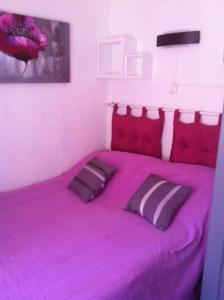 a purple bed with two pillows in a bedroom at Bel appartement 2 chambres mer 400m clim in Cavalaire-sur-Mer