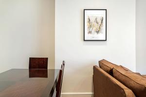 a dining room with a table and a picture on the wall at Cosy Kensington Two Bedroom Flat in London