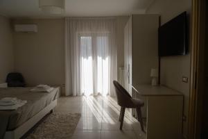 een slaapkamer met een bed, een stoel en een raam bij Donna Filu Casa Vacanze in Santa Maria La Carità