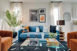 um sofá azul numa sala de estar com uma mesa de vidro em Nashville - 5623, 5625, 5627 & 5629 Lenox Ave - 4 COMBO em Nashville