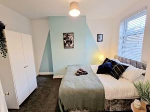 a bedroom with a bed with a dog laying on it at 3 Double-Bedroom House with FREE WiFi by Amazing Spaces Relocations Ltd in Barrow in Furness