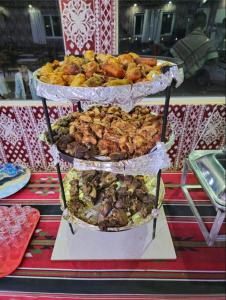 a three tiered display of food on a table at Desert guide camp in Wadi Rum +37 photos