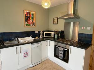 uma cozinha com um lavatório e um fogão forno superior em Peaceful Sea View Home only 5 miles from Inverness em North Kessock