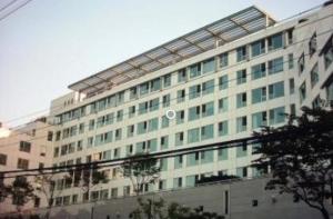 Un grand bâtiment blanc avec de nombreuses fenêtres dans l'établissement Mirae_stay 33 New Open [2 Queen+1 S-Single], à Séoul