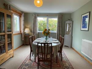 uma sala de jantar com uma mesa com flores em Peaceful Sea View Home only 5 miles from Inverness em North Kessock