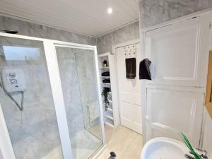 a bathroom with a shower and a sink at 3 Double-Bedroom House with FREE WiFi by Amazing Spaces Relocations Ltd in Barrow in Furness