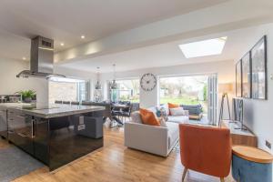 a kitchen and living room with a clock on the wall at Magnificent 3-Bedroom Home with Swim Spa in Cheltenham