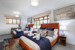 切爾滕納姆的住宿－Magnificent 3-Bedroom Home with Swim Spa，一间卧室配有两张蓝色和白色的床
