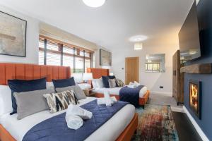 切爾滕納姆的住宿－Magnificent 3-Bedroom Home with Swim Spa，酒店客房设有两张床和壁炉