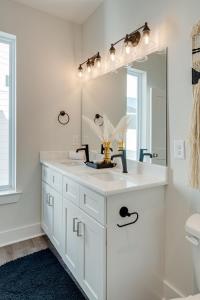 ein weißes Badezimmer mit einem Waschbecken und einem Spiegel in der Unterkunft Nashville - 5625 Lenox Ave in Nashville
