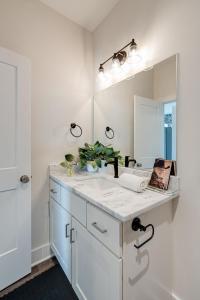 ein Bad mit einem Waschbecken und einem Spiegel in der Unterkunft Nashville - 5625 Lenox Ave in Nashville