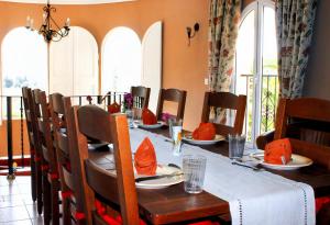 a dining room with a table and chairs with red napkins at Villa Lobos in Lliber