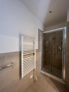 uma casa de banho com um chuveiro e uma cabina de duche em vidro. em Appartamento BN1 em Follonica