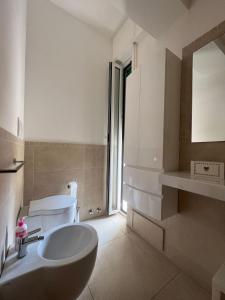 uma casa de banho branca com um lavatório e um WC em Appartamento BN1 em Follonica