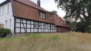 a house with a brown roof and a white at Ferienwohnung an der Wassermühle in Hermannsburg in Hermannsburg