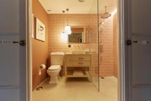 W łazience znajduje się toaleta, umywalka i prysznic. w obiekcie Llimona Suites - Adults Only w mieście Corçà