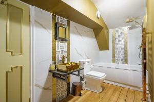 a bathroom with a toilet and a tub and a sink at Huge Deluxe 600 Year Old Essex Manor, Hot Tub, Cinema Room, Sky Tv in Saffron Walden +156 photos