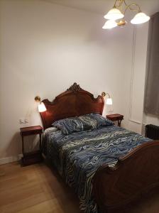 Ce lit se trouve dans une chambre dotée de 2 tables de chevet et de 2 lampes. dans l'établissement Versailles Direct : T2 Authentique et Chaleureux, à Versailles