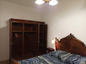 - une chambre avec un lit et une armoire en bois dans l'établissement Versailles Direct : T2 Authentique et Chaleureux, à Versailles