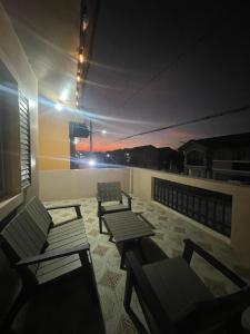 a rooftop patio with two chairs and tables on a building at Camella Cerritos Gensan in General Santos