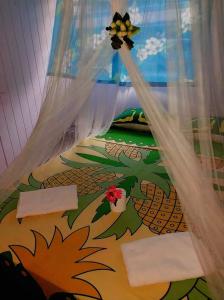 un letto con copriletto con disegno ananas; di Tapuhere Homestay Room a Fare (Huahine Nui)