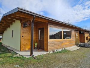 a small wooden cabin with a large window at Bosquey Ranch B&B in Alice Castello
